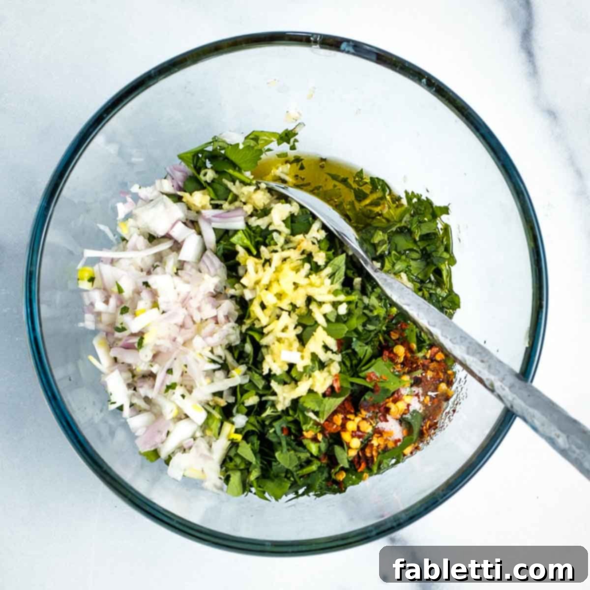Zesty Chimichurri Portobello Steaks 11 Small glass mixing bowl with chopped fresh herbs, garlic, shallot, spices, olive oil and red wine vinegar.