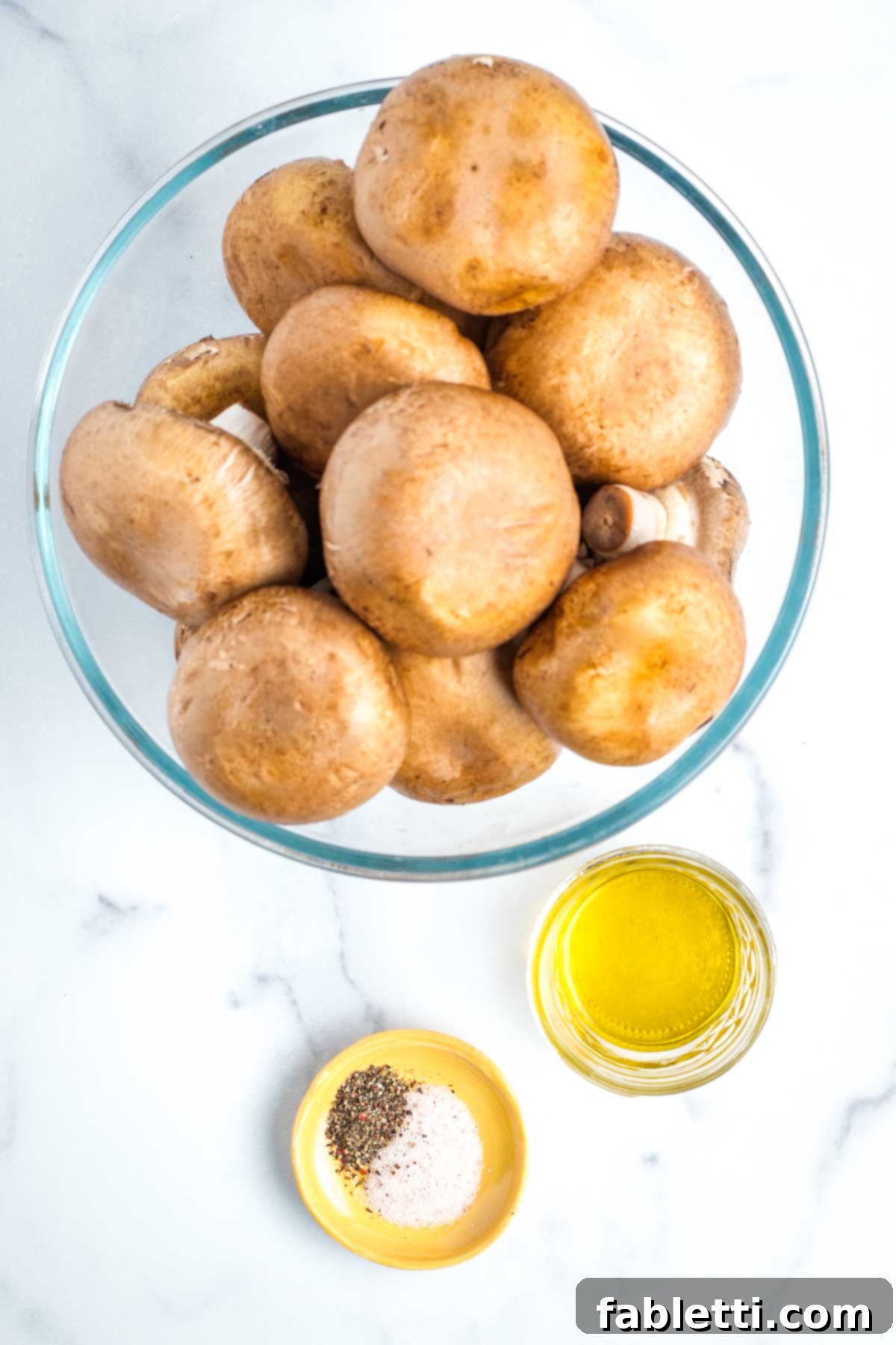Zesty Chimichurri Portobello Steaks 3 Bowl full of bella mushrooms plus a small dish of olive oil and one of salt and pepper.