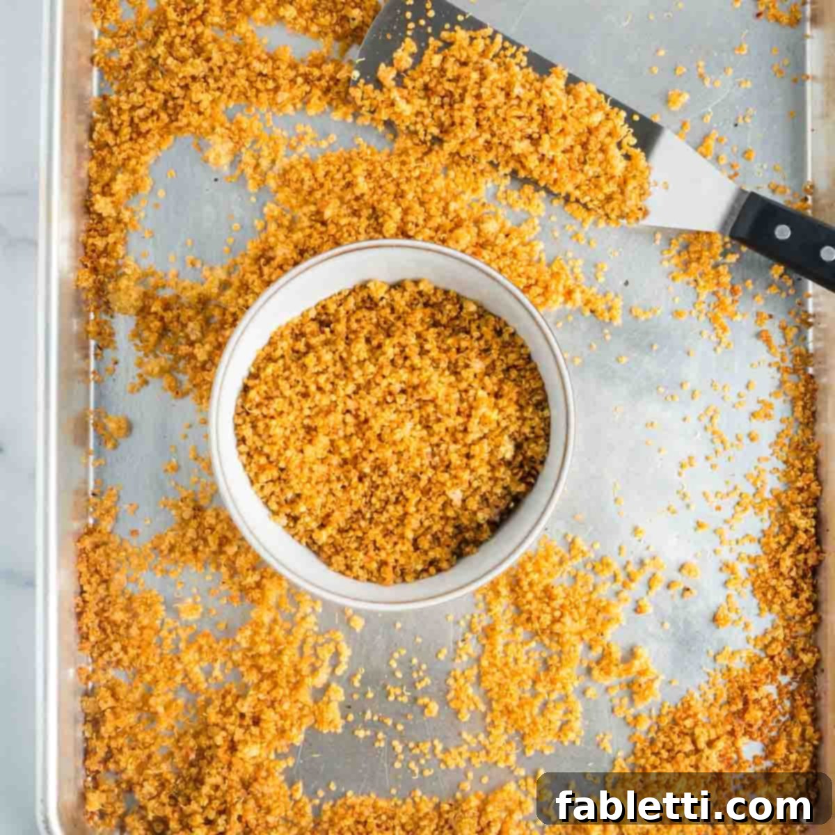 A metal spatula scooping golden, crispy quinoa into a rustic bowl, highlighting its perfect texture.