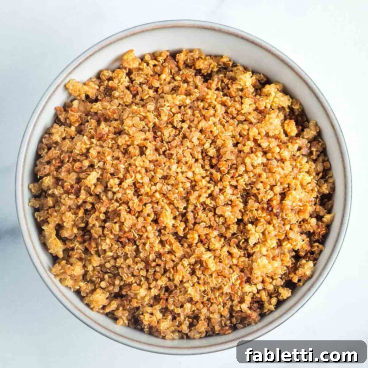 A charming bowl overflowing with perfectly golden, crispy quinoa, ready for serving or storage.
