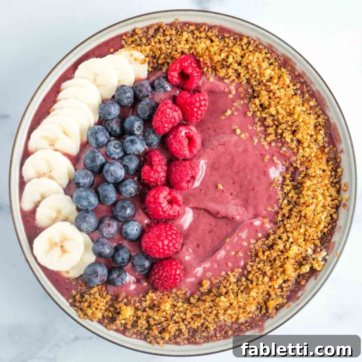 A beautifully arranged vegan fruit dip with colorful fruit skewers, generously sprinkled with sweet crispy quinoa for added texture.