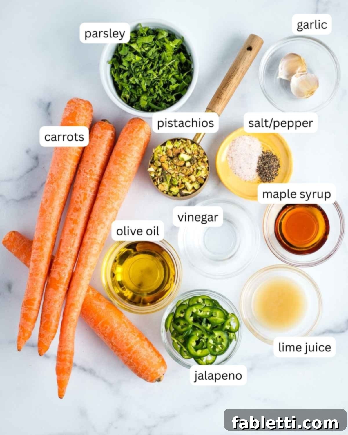 Sweet Heat Shaved Carrot Salad 3 A beautifully arranged flat lay of labeled ingredients for the sweet and spicy carrot ribbon salad: fresh carrots, vibrant parsley, crunchy pistachios, fiery jalapenos, olive oil, white vinegar, fresh lime juice, and rich maple syrup.
