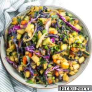 Simple Skillet Vegan Potato & Vegetable Hash 17 A colorful and appetizing vegan potato and veggie hash, featuring diced potatoes mixed with vibrant kale, red pepper, purple cabbage, and zucchini, served hot.
