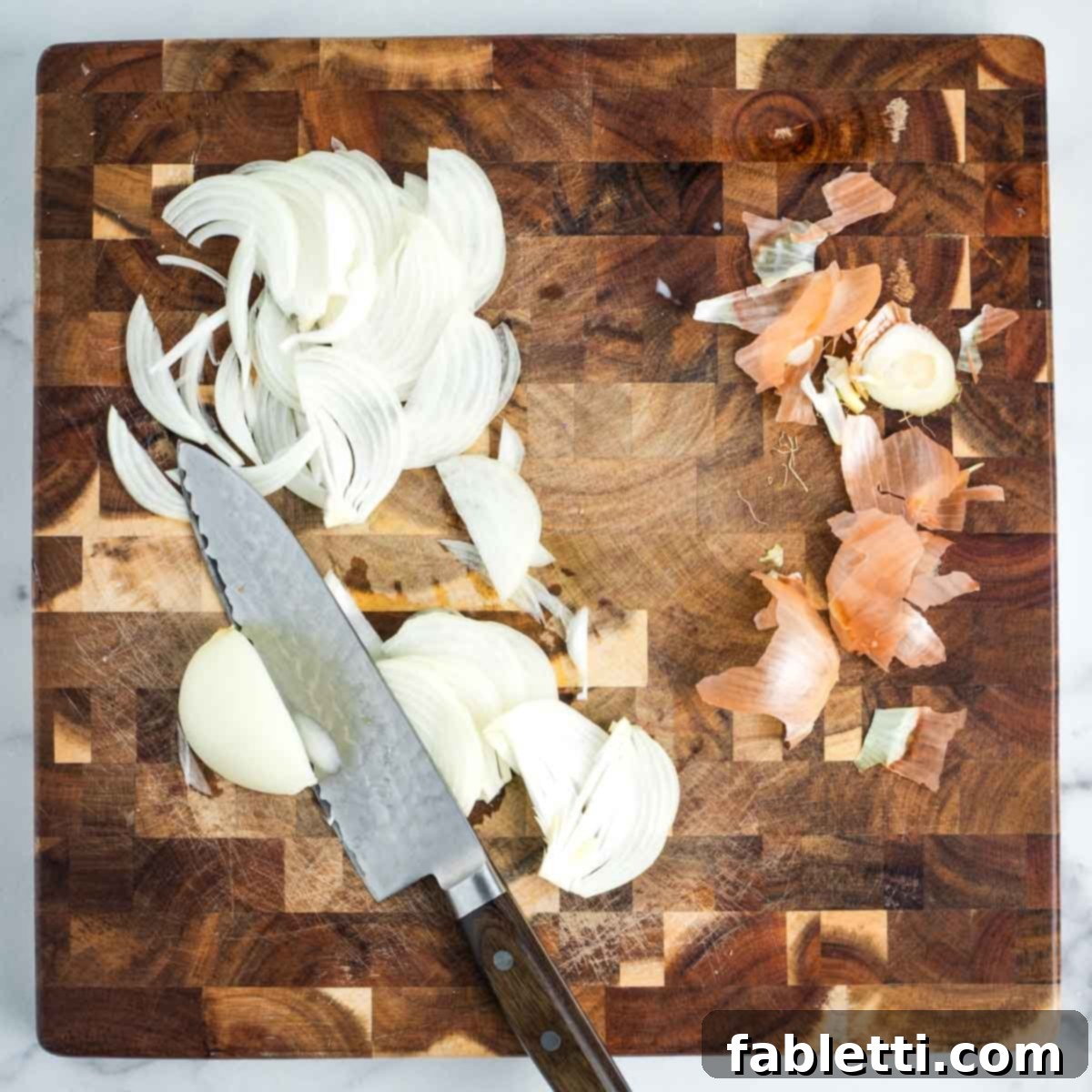 Simple Skillet Vegan Potato & Vegetable Hash 4 Chef thinly slicing an onion on a wooden cutting board, demonstrating precision knife skills.