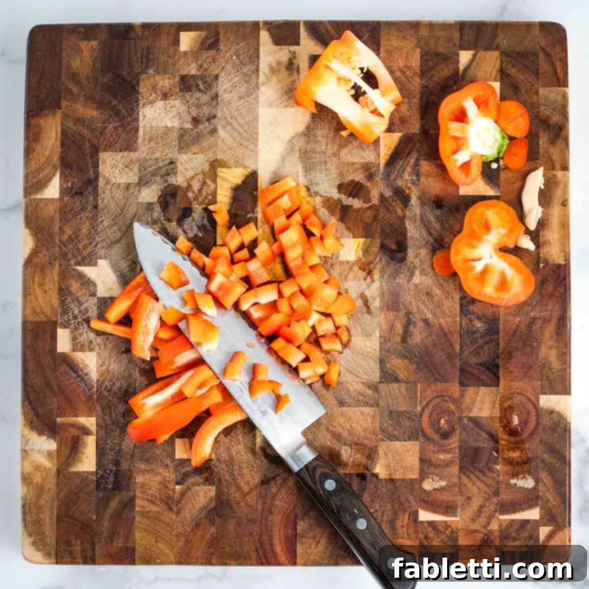 Simple Skillet Vegan Potato & Vegetable Hash 6 Detailed step-by-step demonstration of how to expertly dice a red bell pepper on a wooden cutting board.