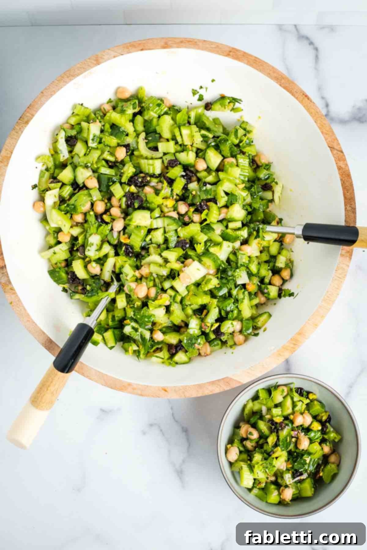 Crisp Celery & Chickpea Salad with a Sweet Raisin Twist 14 A vibrant close-up of the chopped celery salad, featuring chickpeas, golden raisins, and green pistachios, perfectly dressed and mixed, showcasing its fresh, inviting texture.