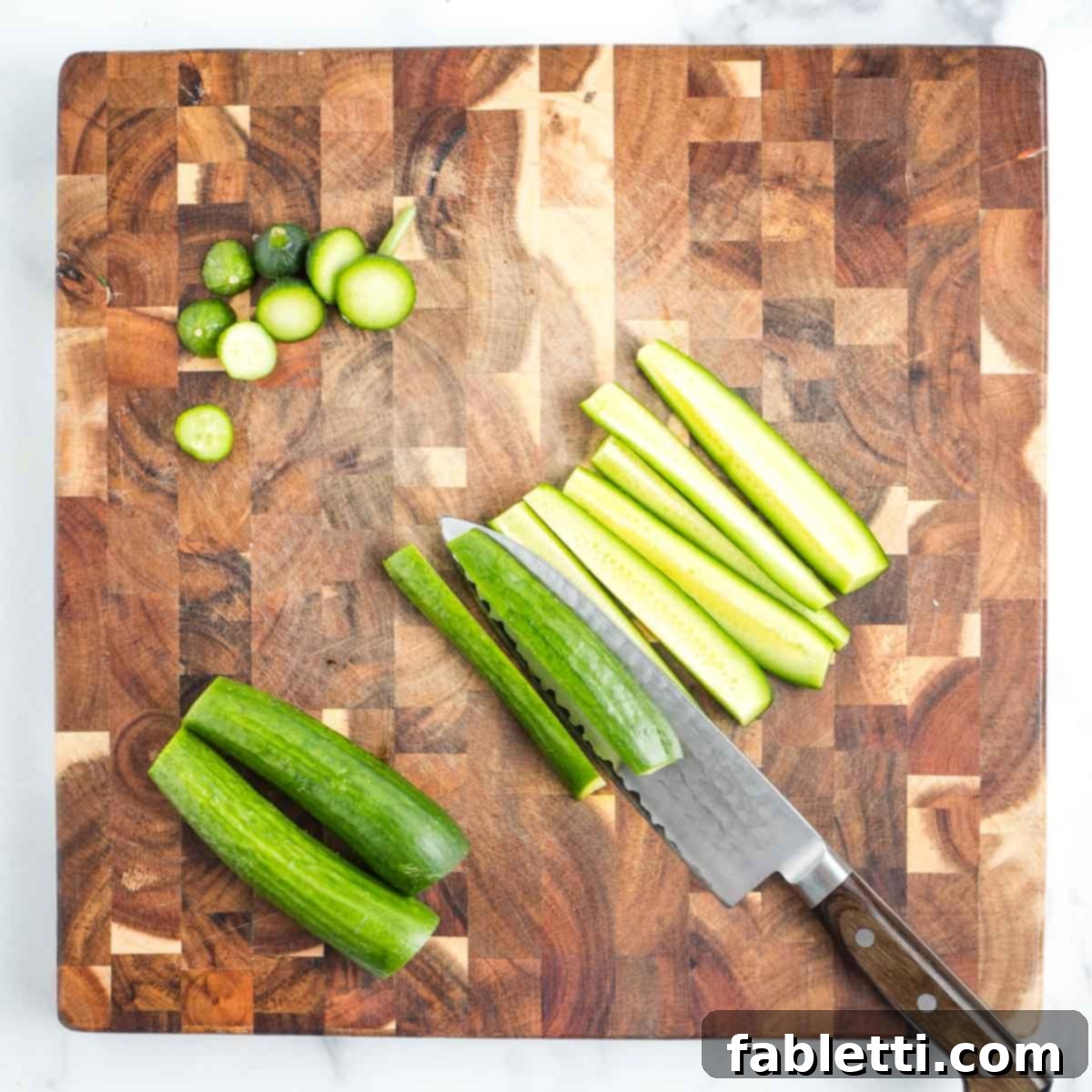 Crisp Celery & Chickpea Salad with a Sweet Raisin Twist 10 A cucumber, with its ends neatly trimmed, is expertly sliced lengthwise into long, slender strips on a wooden cutting board, preparing it for dicing.