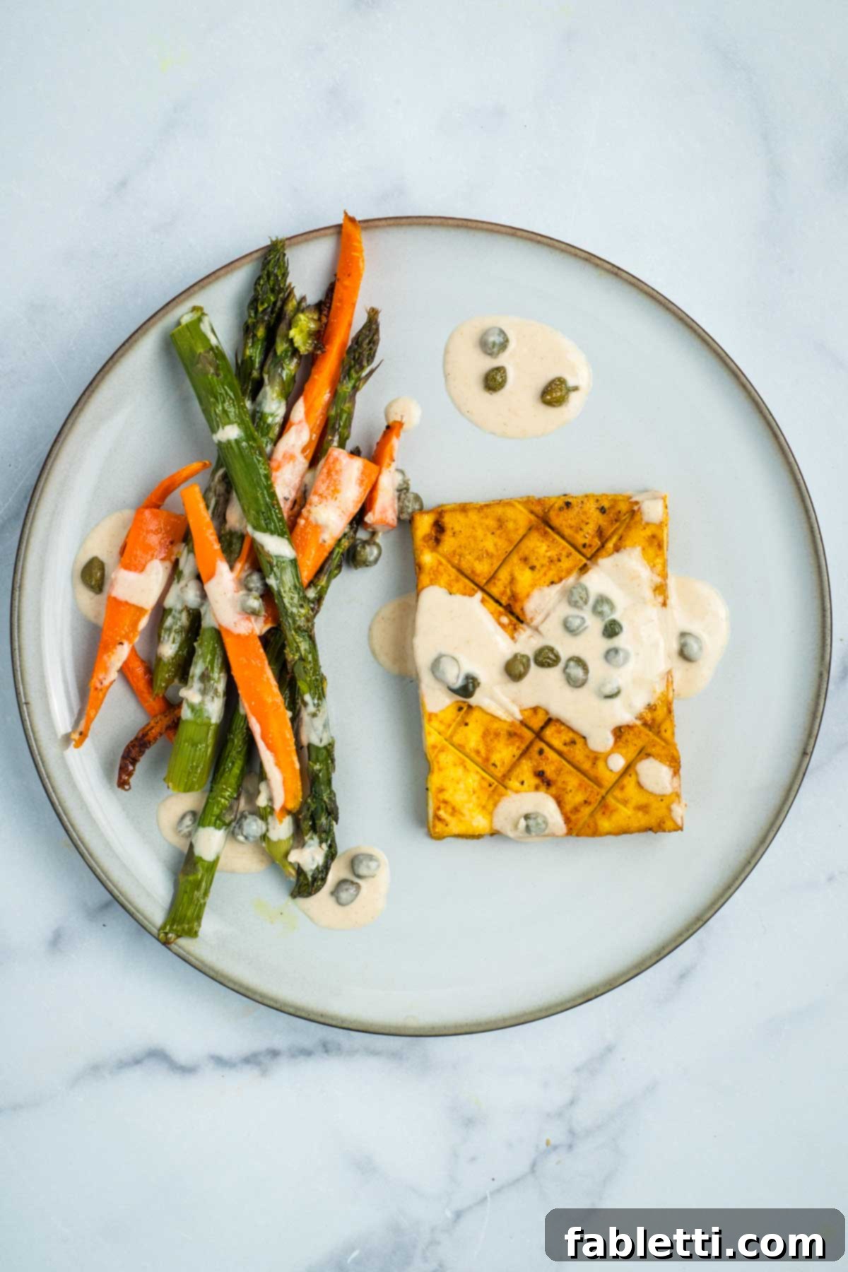 Carrots, Asparagus and Tofu Steaks drizzled with a lemon caper tahini sauce.