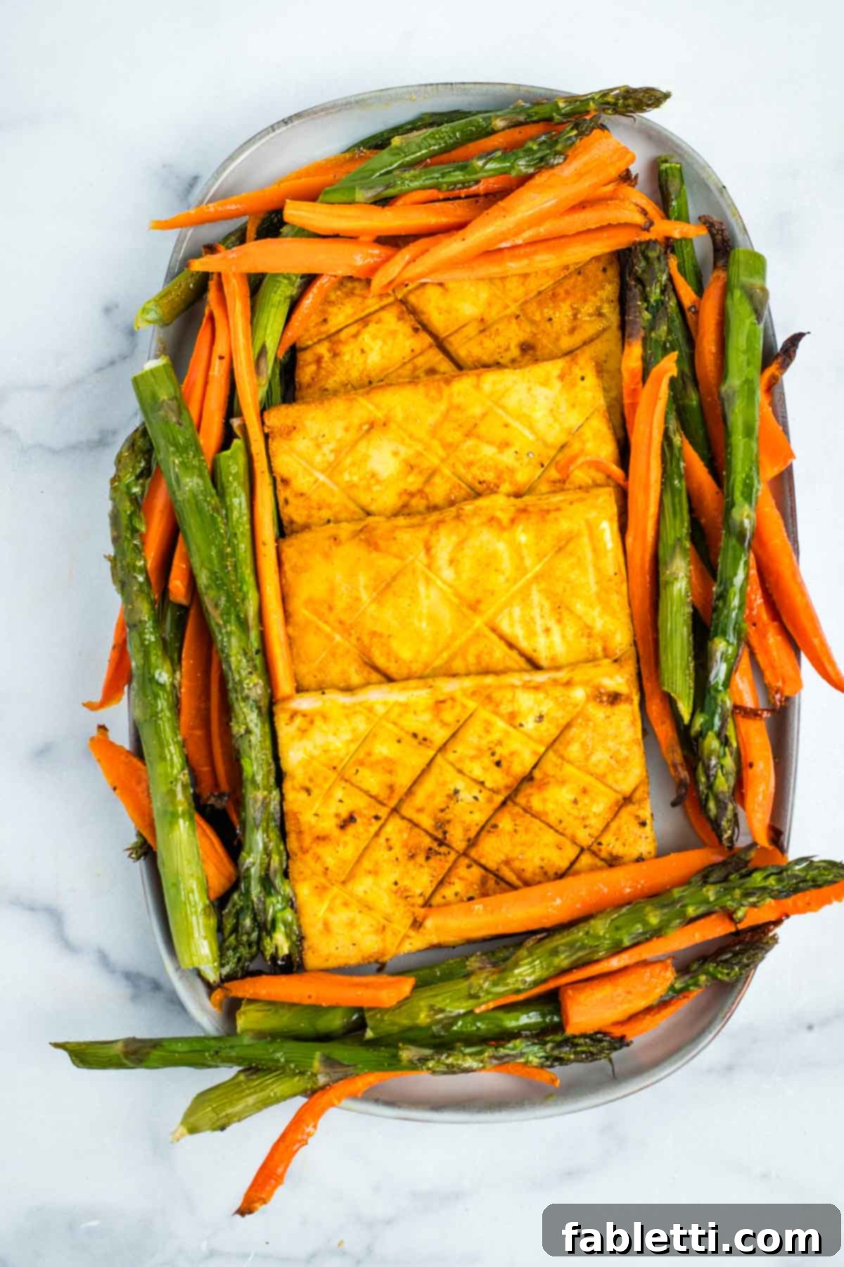 Tofu steaks and roasted vegetables on a platter.