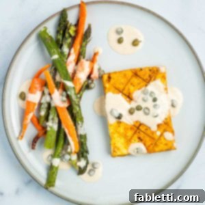 Tofu steak, carrot and asparagus drizzled with tahini lemon caper sauce.