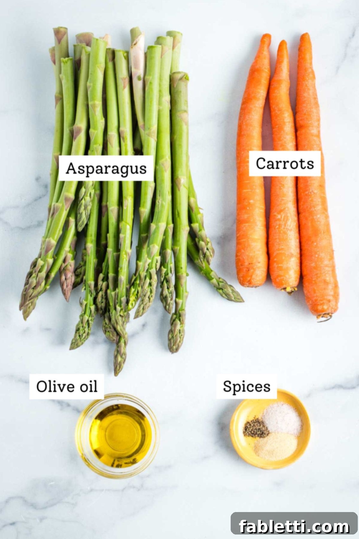 Pile of asparagus, 3 carrots, dish of olive oil and some spices on a really small plate.