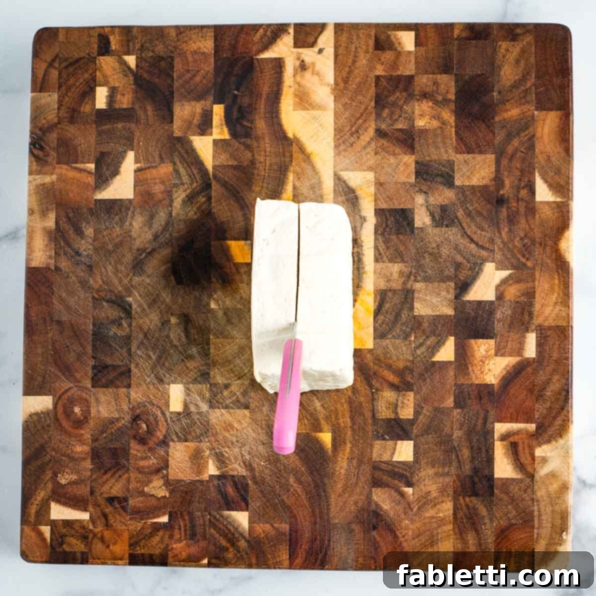 Cutting through a block of tofu.