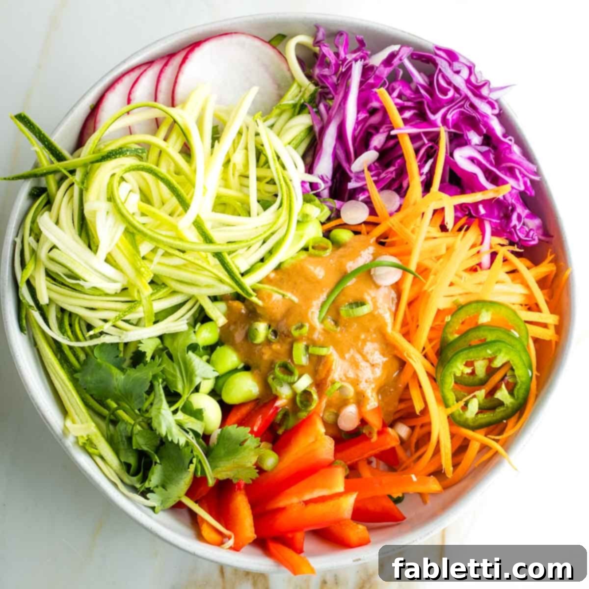 Fresh Spring Roll Salad Bowl with Creamy Peanut Sauce 18 Brightly colored cabbage, carrots, peppers, radish, jalapeno with a pool of peanut sauce in the center.