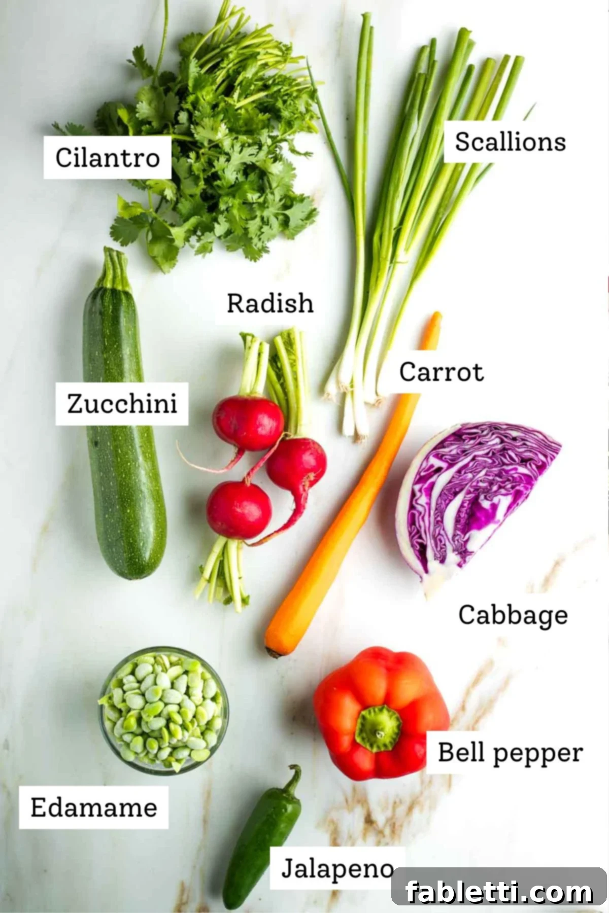 Fresh Spring Roll Salad Bowl with Creamy Peanut Sauce 3 Labeled raw ingredients: cilantro, scallion, zucchini, radish, cabbage, carrot, bell pepper, jalapeno and shelled edamame beans.