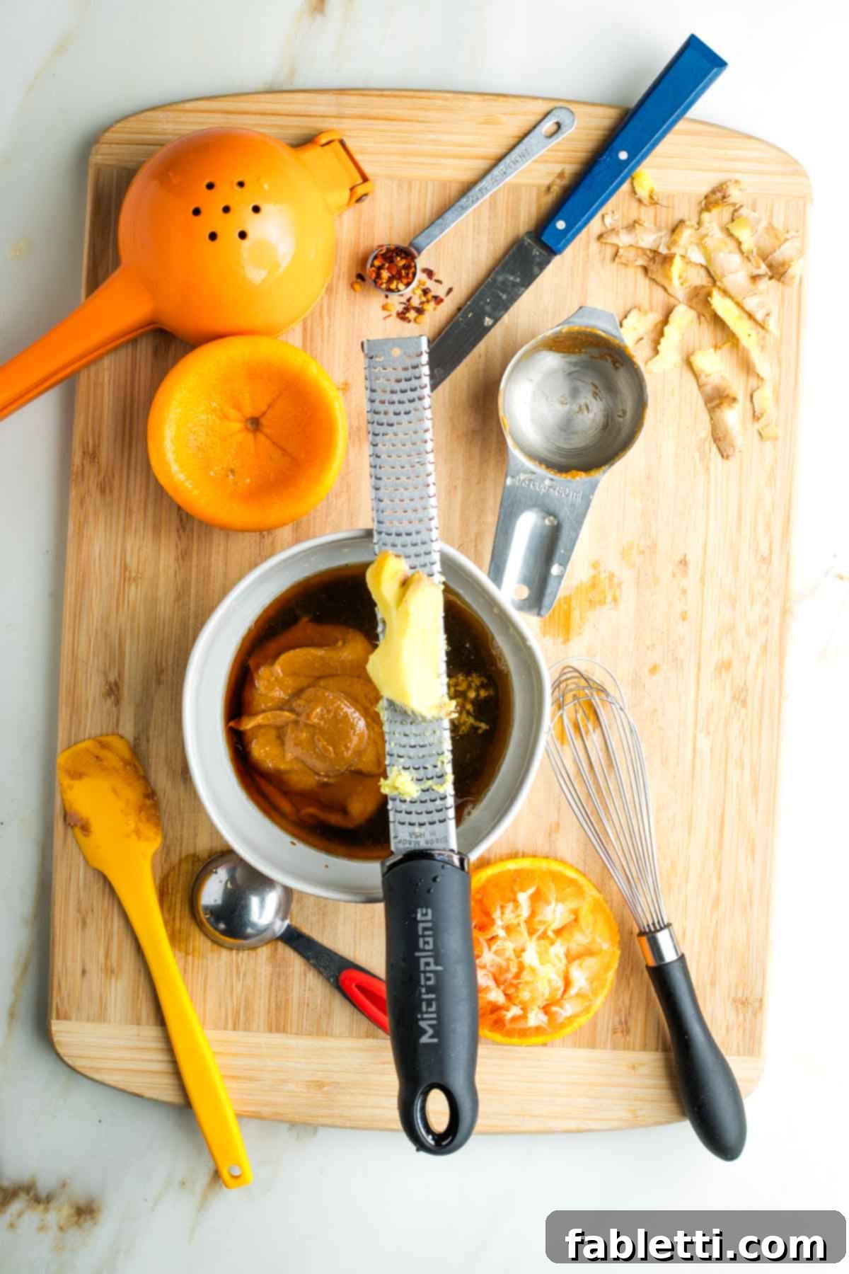 Fresh Spring Roll Salad Bowl with Creamy Peanut Sauce 6 Grating fresh ginger over a bowl with brown liquid and a dollop of peanut butter.