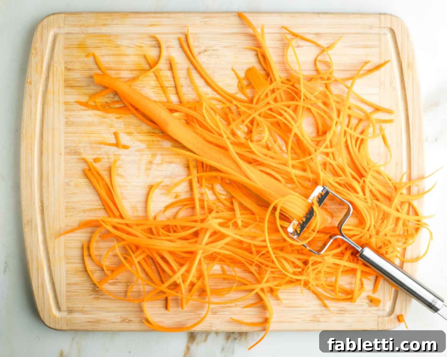Fresh Spring Roll Salad Bowl with Creamy Peanut Sauce 10 Creating thin strips of carrot with a julienne peeler.