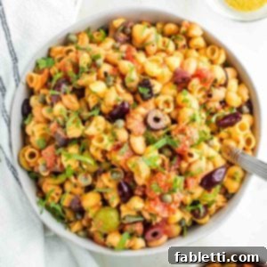 Zesty White Bean Puttanesca Pasta 13 Pasta, white beans, olives and capers with tomatoes and fresh parsley, presented in a bowl.