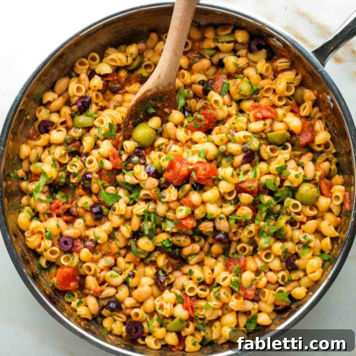 Zesty White Bean Puttanesca Pasta 10 Small pasta, white beans, black and green olives, capers, and fresh parsley tossed in a chunky tomato base in a skillet.