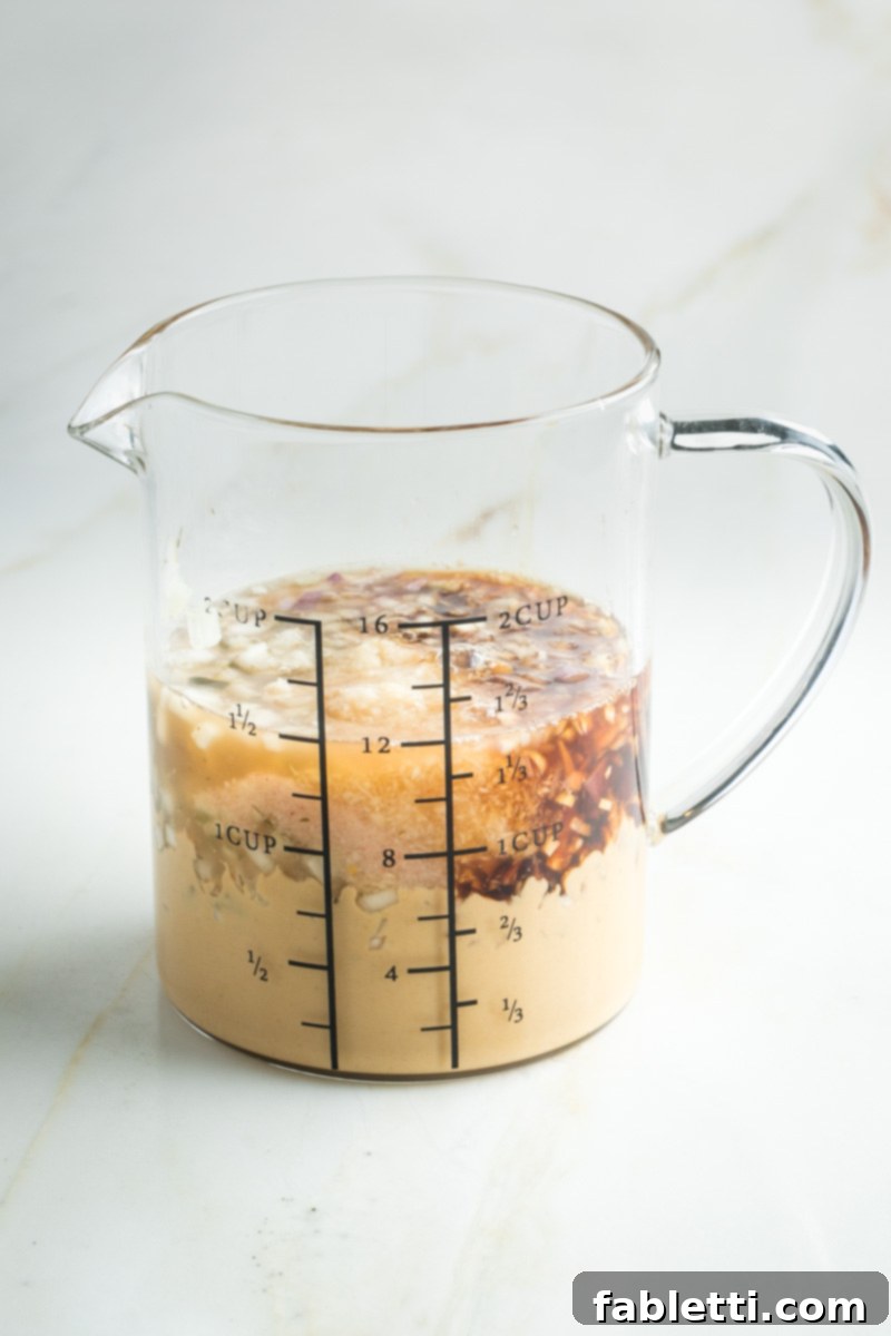 Glass measuring cup with ingredients to make Russian dressing.