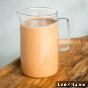 Creamy Russian dressing in a small glass pitcher.