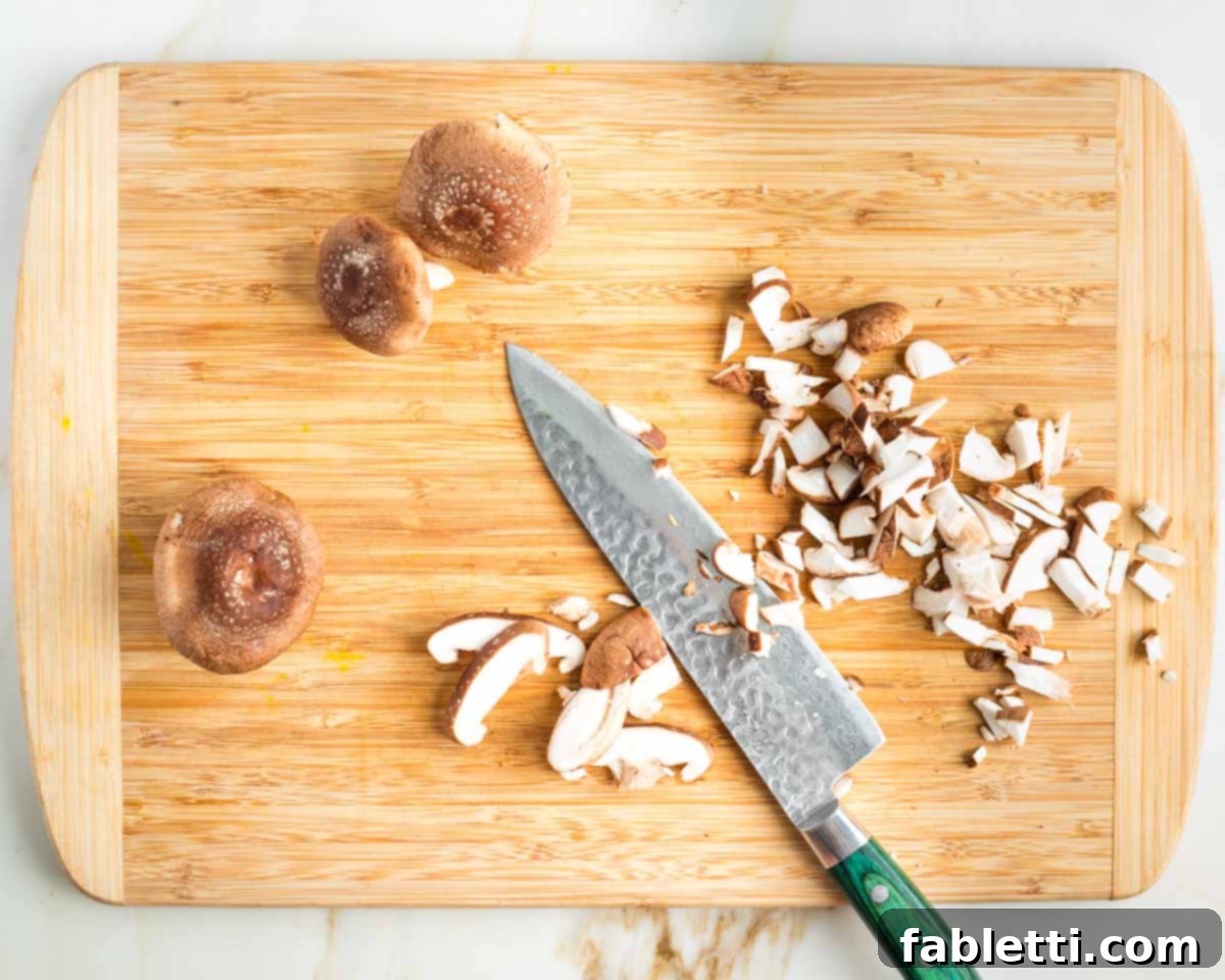 Smoky Shiitake and Zesty Russian Vegan Wedge 7 Chef's knife dicing shiitake mushrooms into small pieces for the bacon crumbles.