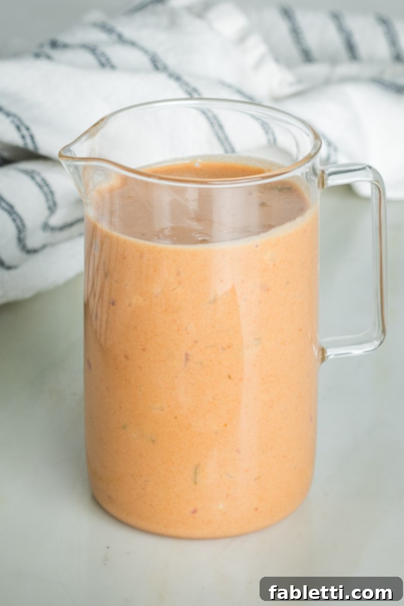 Smoky Shiitake and Zesty Russian Vegan Wedge 9 Smooth, pourable Russian dressing in a pitcher, ready to be drizzled over the salad.