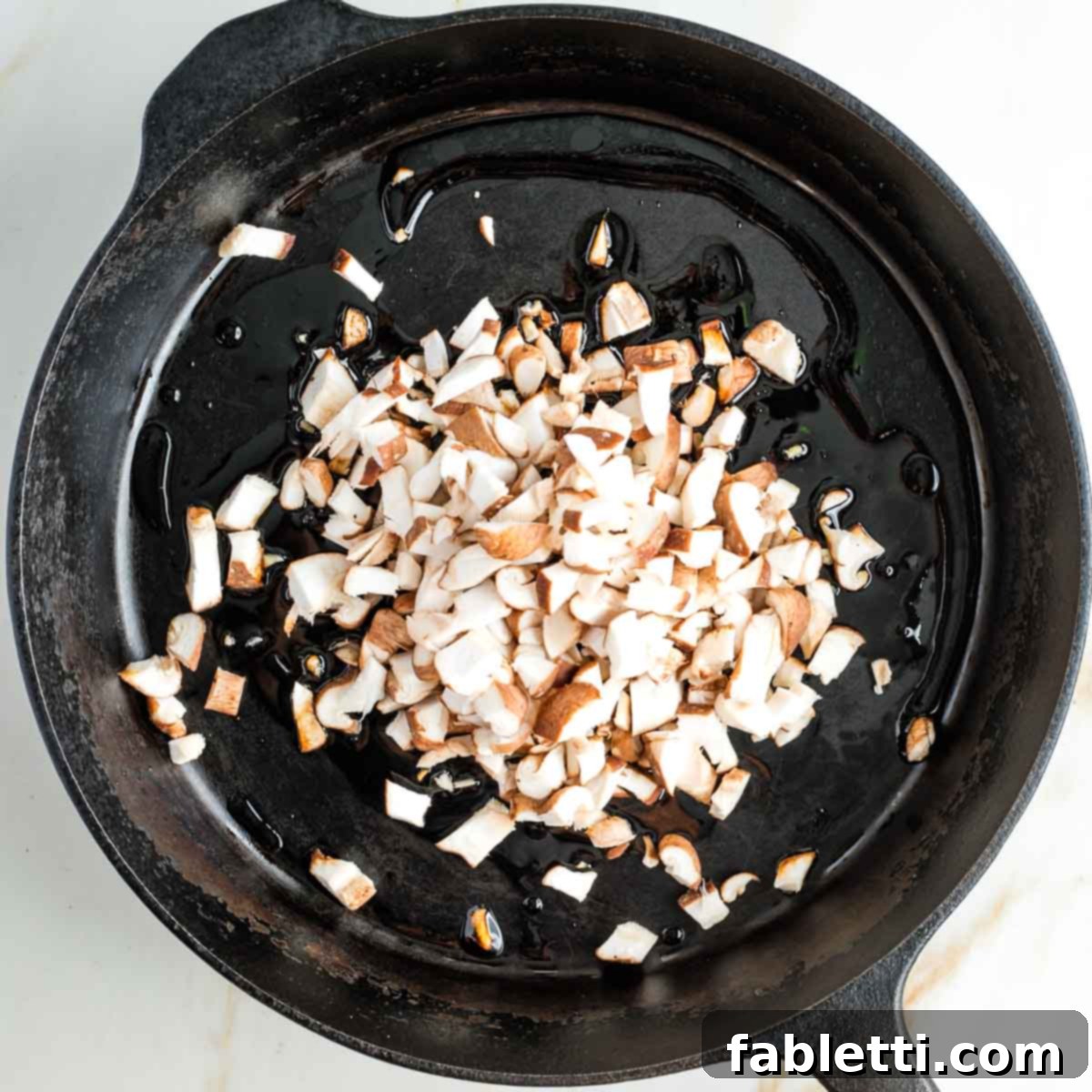 Smoky Shiitake and Zesty Russian Vegan Wedge 10 Diced shiitake mushrooms beginning to sauté in a cast iron skillet with oil and tamari.