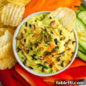 Caramelized Zucchini and Onion Creamy Dip 16 Zucchini and onion dip sprinkled with crispy onions, parsley and paprika. Surrounded by colorful veggies and chips.