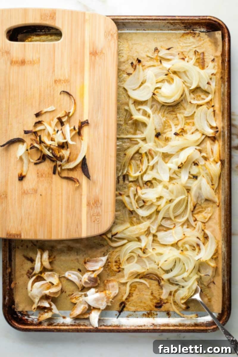 Caramelized Zucchini and Onion Creamy Dip 9 A chef carefully separating and setting aside the crispiest roasted onion slices from a baking tray, destined for garnish.