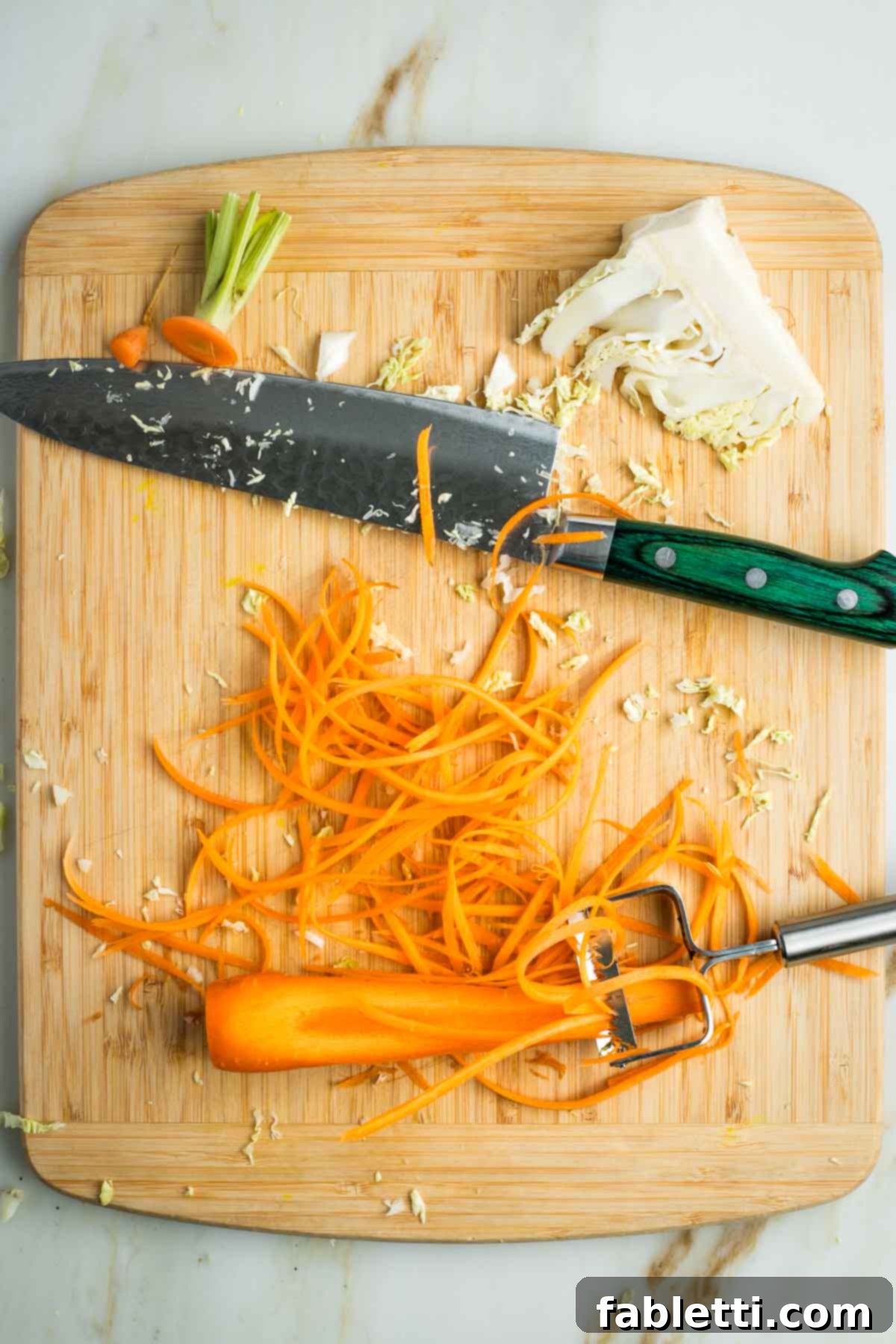 Using a julienne peeler on a carrot to create long and super thin slices.