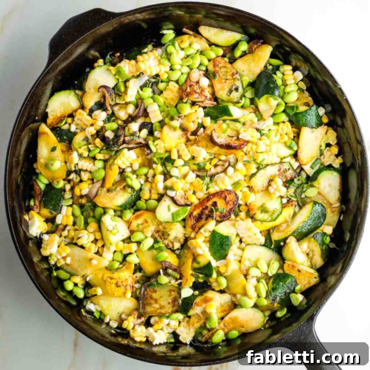 Vegan Zucchini Skillet Dinner in Just 20 Minutes 12 Zucchini, corn, edamame, mushrooms and scallions cooking in a cast iron skillet.