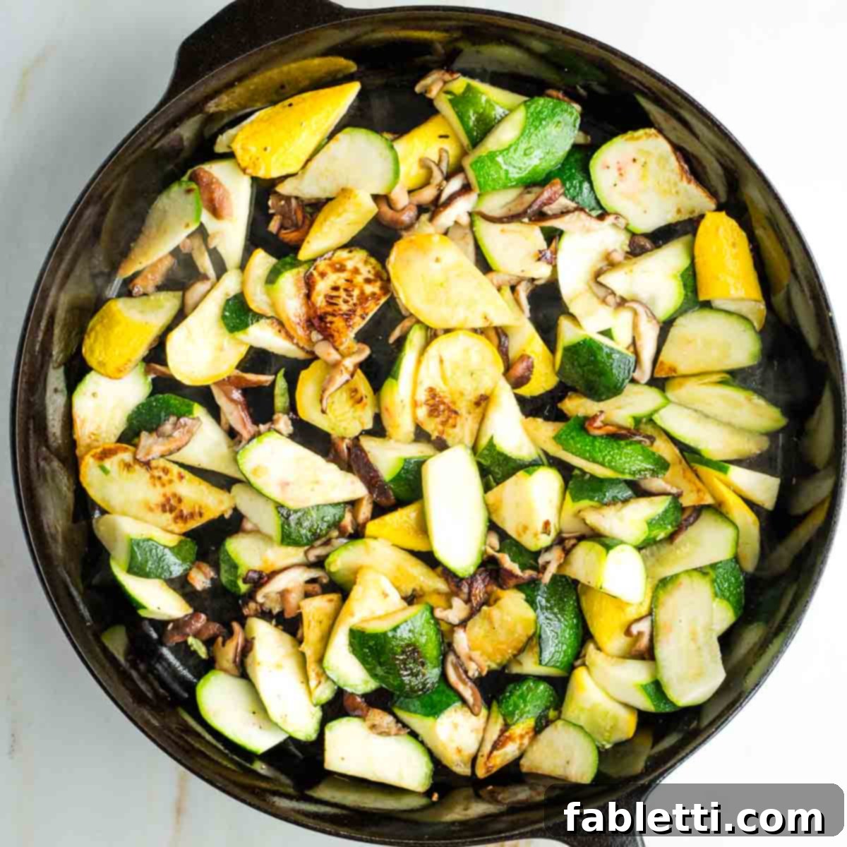 Vegan Zucchini Skillet Dinner in Just 20 Minutes 9 Chunks of zucchini and summer squash with mushrooms, charred in a skillet.