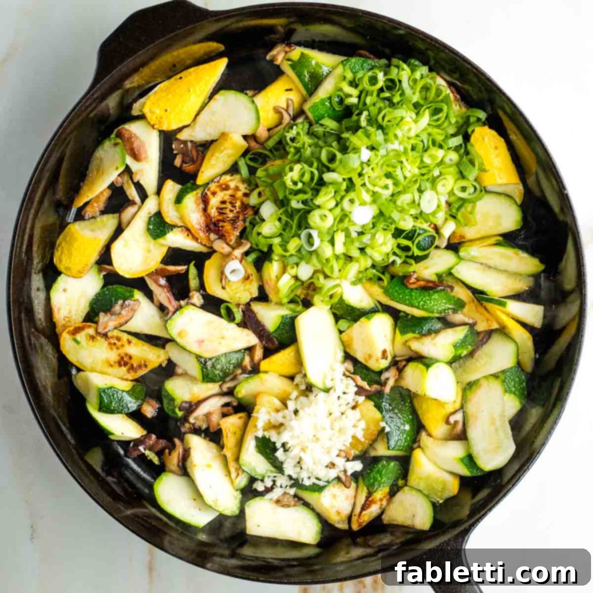 Vegan Zucchini Skillet Dinner in Just 20 Minutes 10 Sliced scallions and minced garlic on top of charred zucchini and mushrooms.