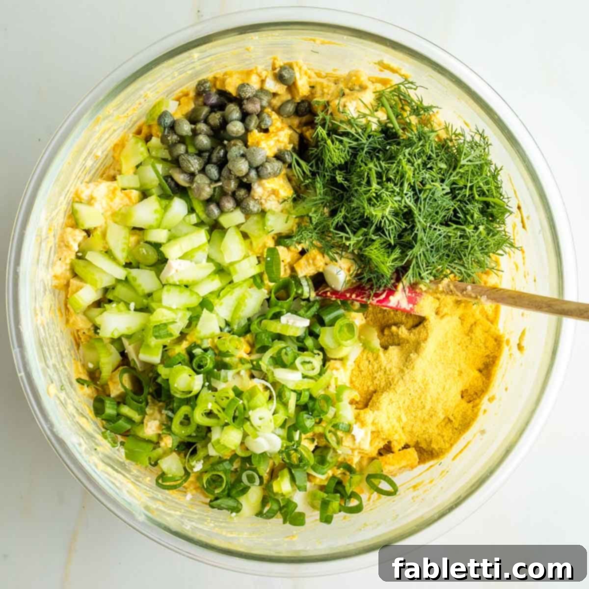 Zingy Vegan Tofu Egg Salad 15 Diced celery, minced dill, sliced scallions, capers, spices and nutritional yeast over a creamy yellow sauced tofu pieces.