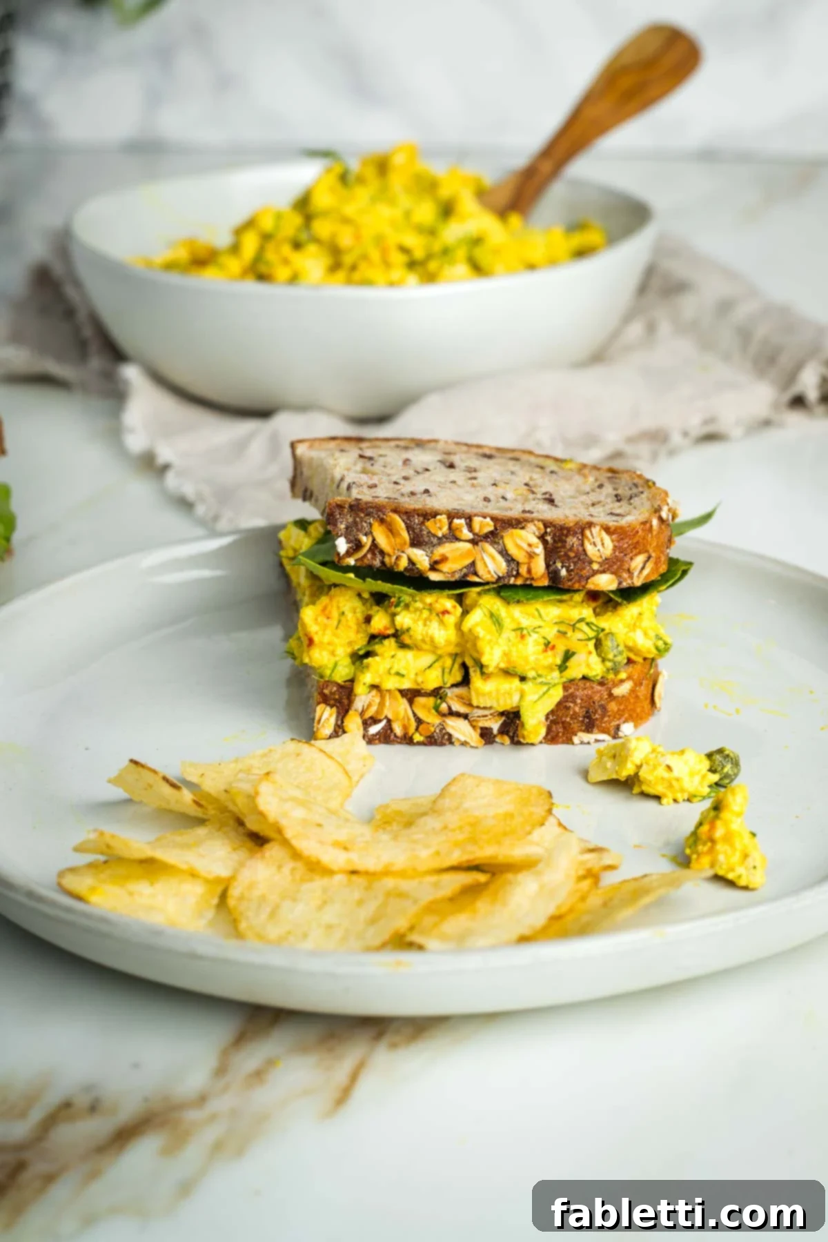 Zingy Vegan Tofu Egg Salad 17 Half a vegan egg salad sandwich on sourdough with lettuce.