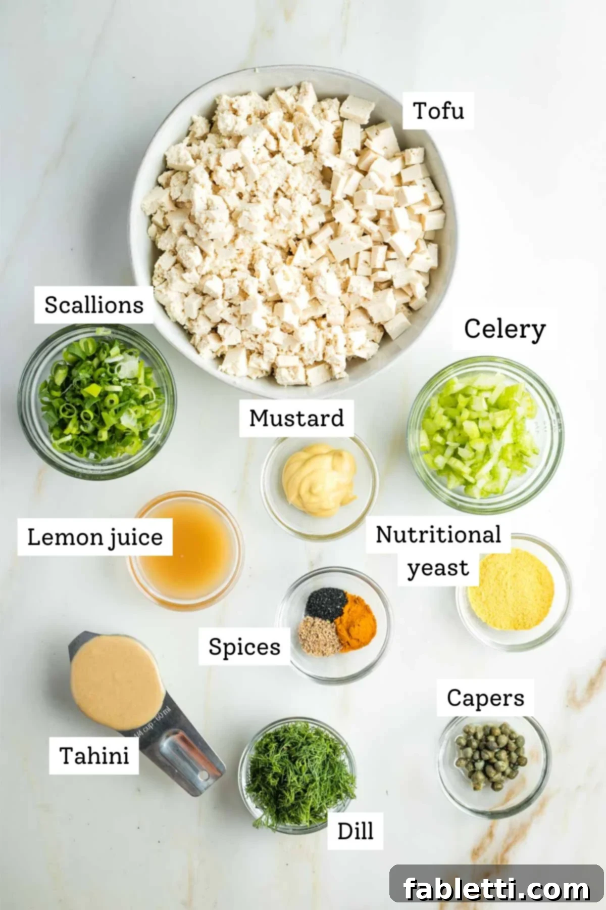 Zingy Vegan Tofu Egg Salad 3 Labeled ingredients for vegan egg salad: tofu, scallions, mustard, lemon juice, tahini, spices, capers, celery. nutritional yeast.