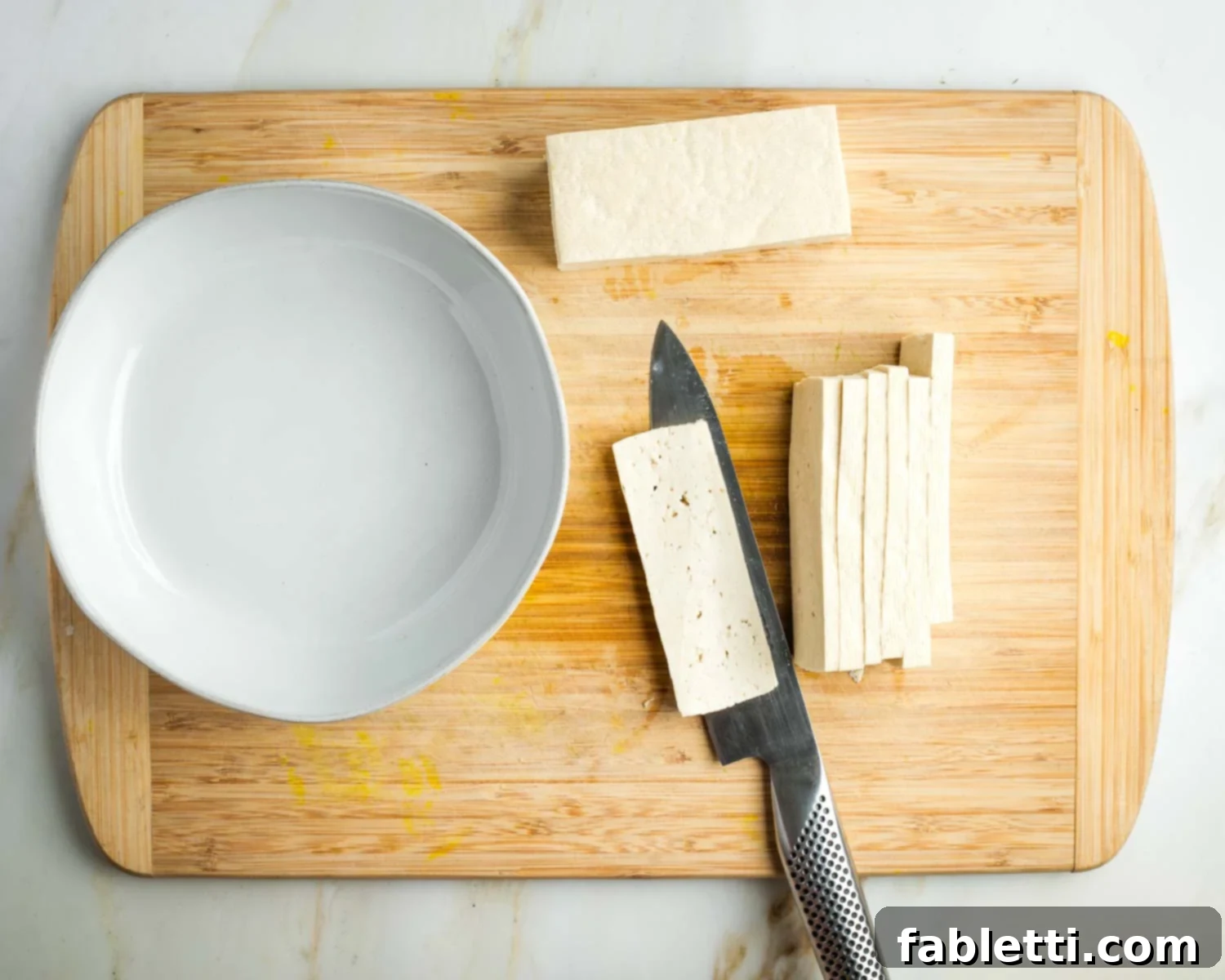 Zingy Vegan Tofu Egg Salad 8 Cutting half a block of tofu into thin slices.