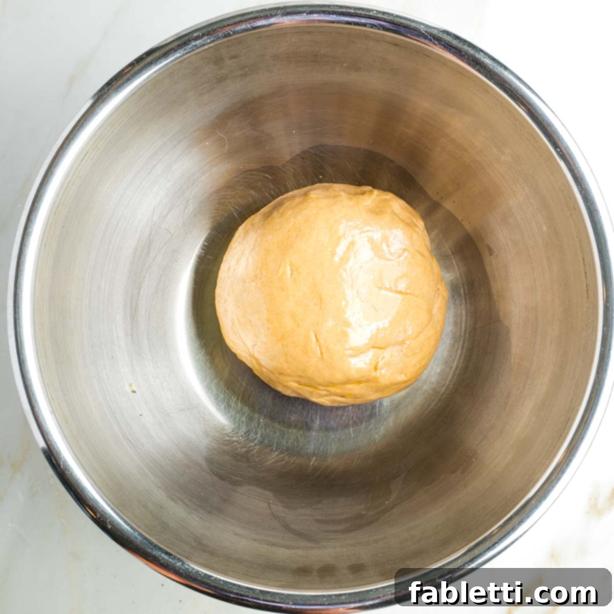 Pillowy Sweet Challah Crown 19 A large metal bowl contains a perfectly oiled ball of challah dough, ready for its first rise.