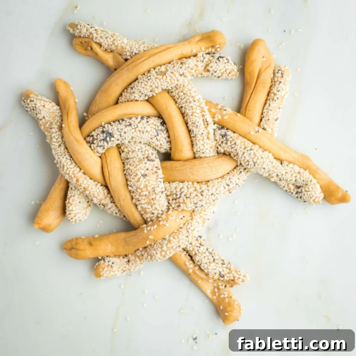 Pillowy Sweet Challah Crown 30 The eight-strand challah braid progresses, with seeded and plain strands meticulously kept together, forming a tight and uniform weave across the entire round loaf.