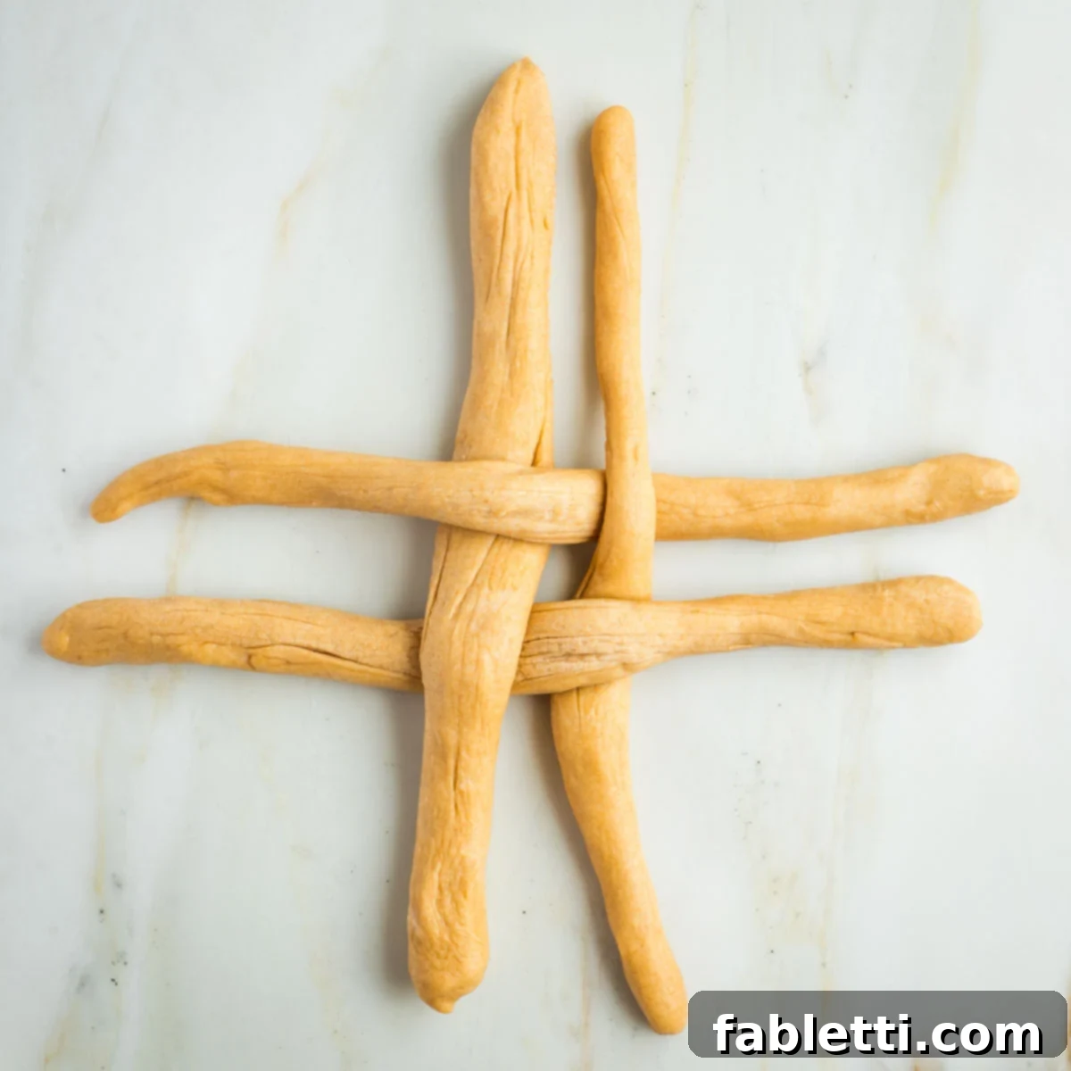 Pillowy Sweet Challah Crown 33 Four strands of dough, 2 horizontal, 2 vertical in a criss cross pattern.