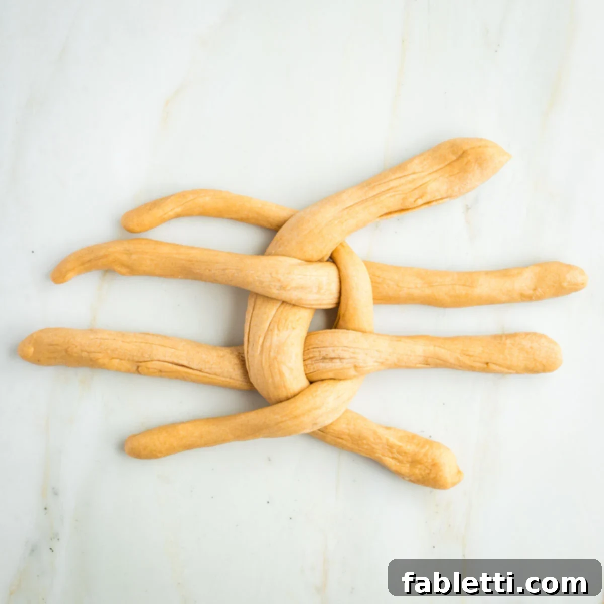 Pillowy Sweet Challah Crown 34 Long ropes of dough, woven into a criss cross pattern.