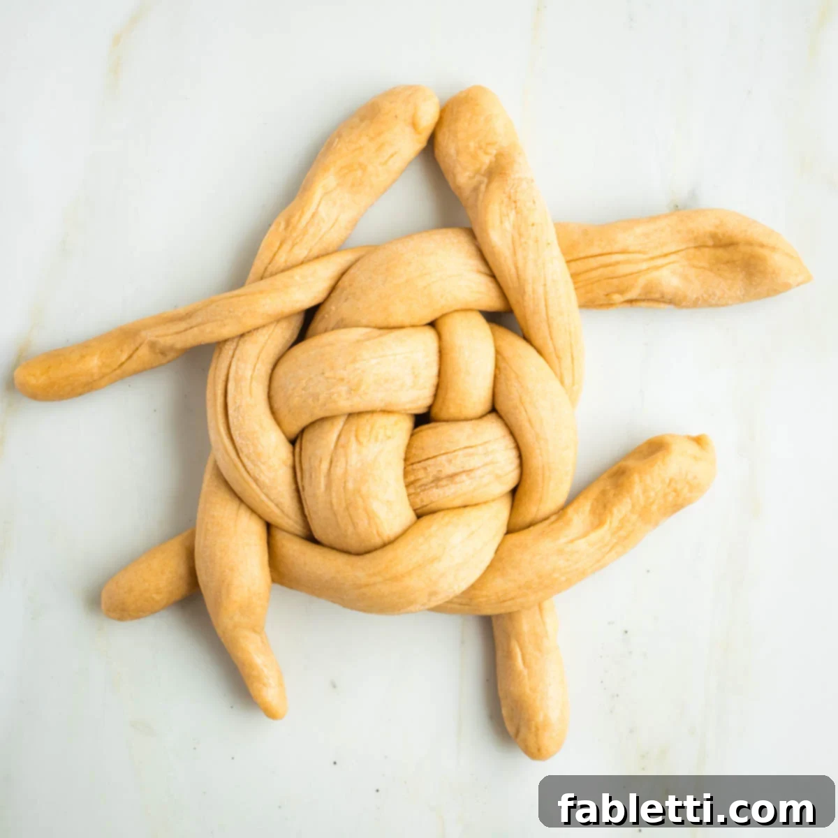 Pillowy Sweet Challah Crown 36 Weaving ropes of dough over and under in a circular pattern.