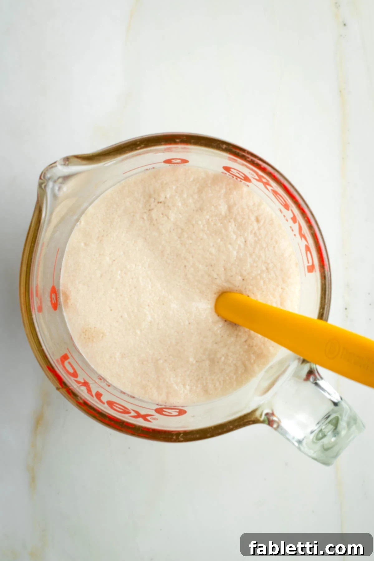 Pillowy Sweet Challah Crown 7 A top-down view of successfully proofed yeast, showcasing a thick, bubbly, and frothy layer on the surface of the liquid.