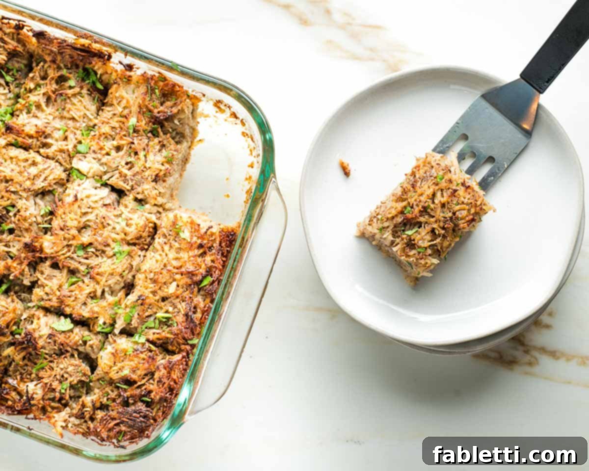 Ultimate Vegan Potato Kugel 2 Spatula serving a piece of crispy vegan potato kugel from the baking dish, with the golden-brown batch visible.