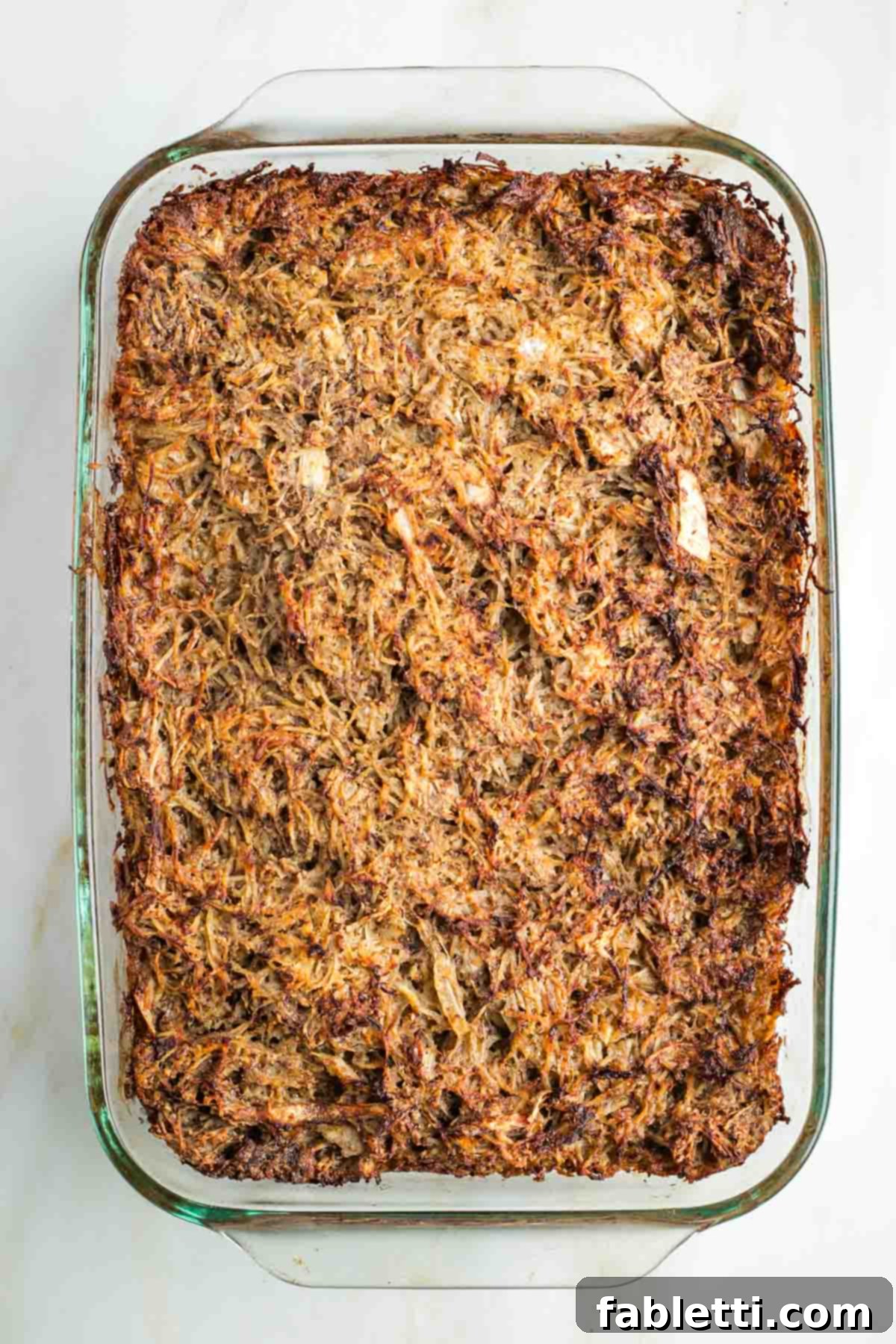 Ultimate Vegan Potato Kugel 13 Golden-brown potato kugel in a glass baking pan, fresh out of the oven.