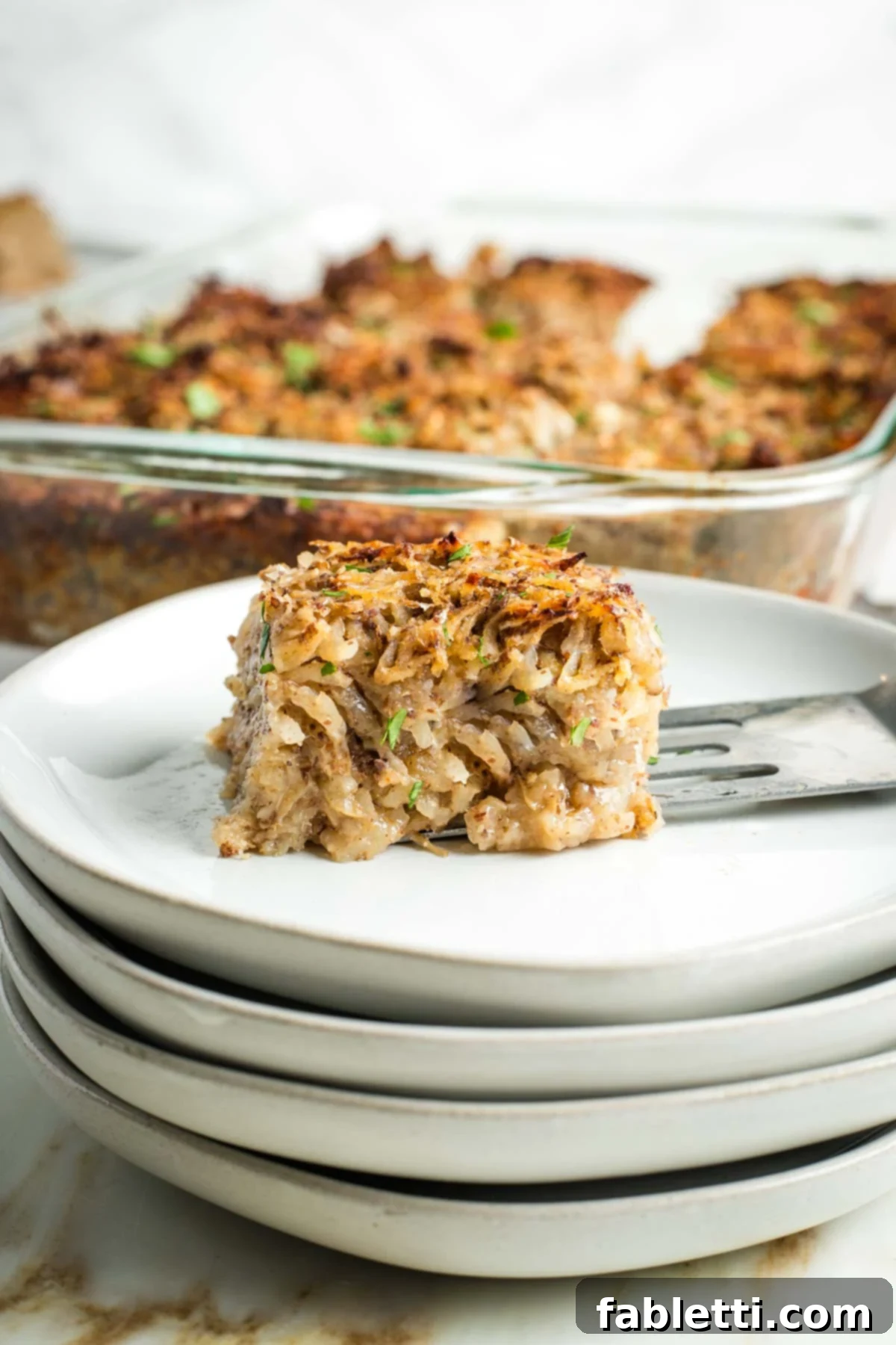 Ultimate Vegan Potato Kugel 15 Side view of a perfectly baked piece of vegan potato kugel, showing its layers and crispy texture.