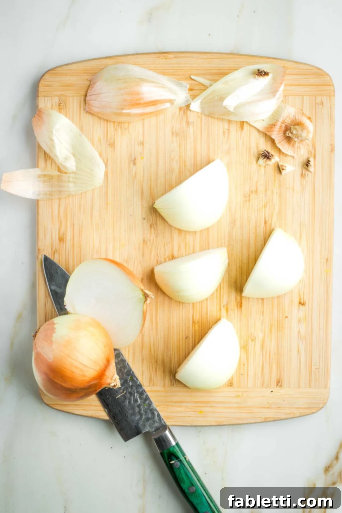 Ultimate Vegan Potato Kugel 4 Onions, peeled and cut into quarters, ready for shredding.