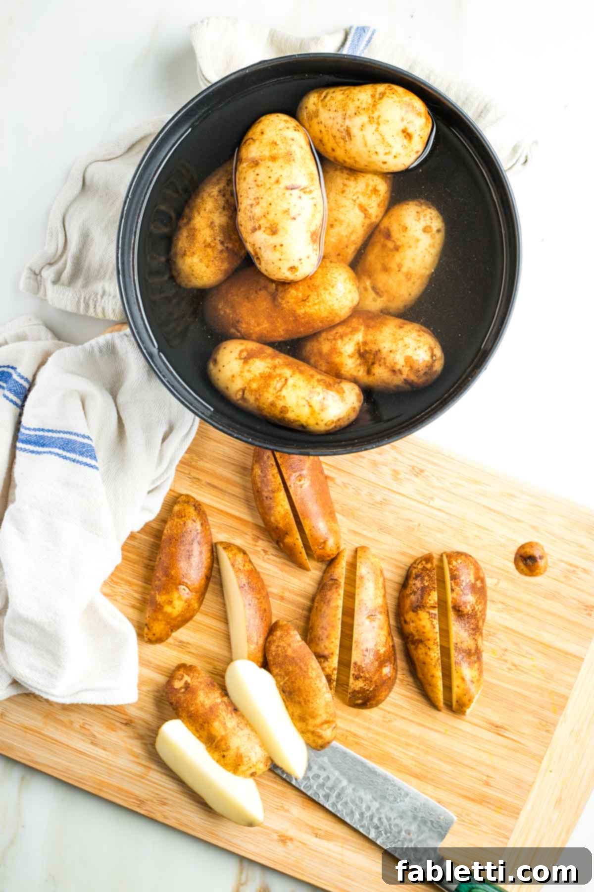 Ultimate Vegan Potato Kugel 6 Bowl of water filled with potatoes and a cutting board, slicing into long quarters.