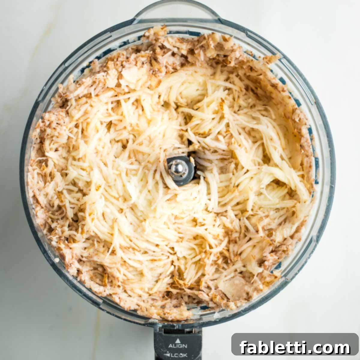 Ultimate Vegan Potato Kugel 8 Unpeeled potatoes and onions, thinly shredded into the bowl of a food processor.