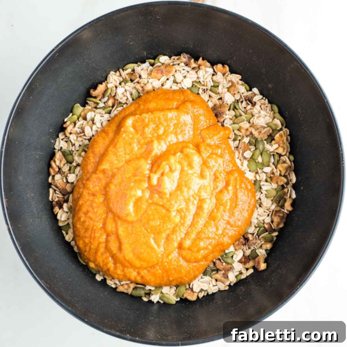 Cozy Pumpkin Spice Granola 9 Mixture of nuts, seeds and oats topped with an orange pumpkin mixture.